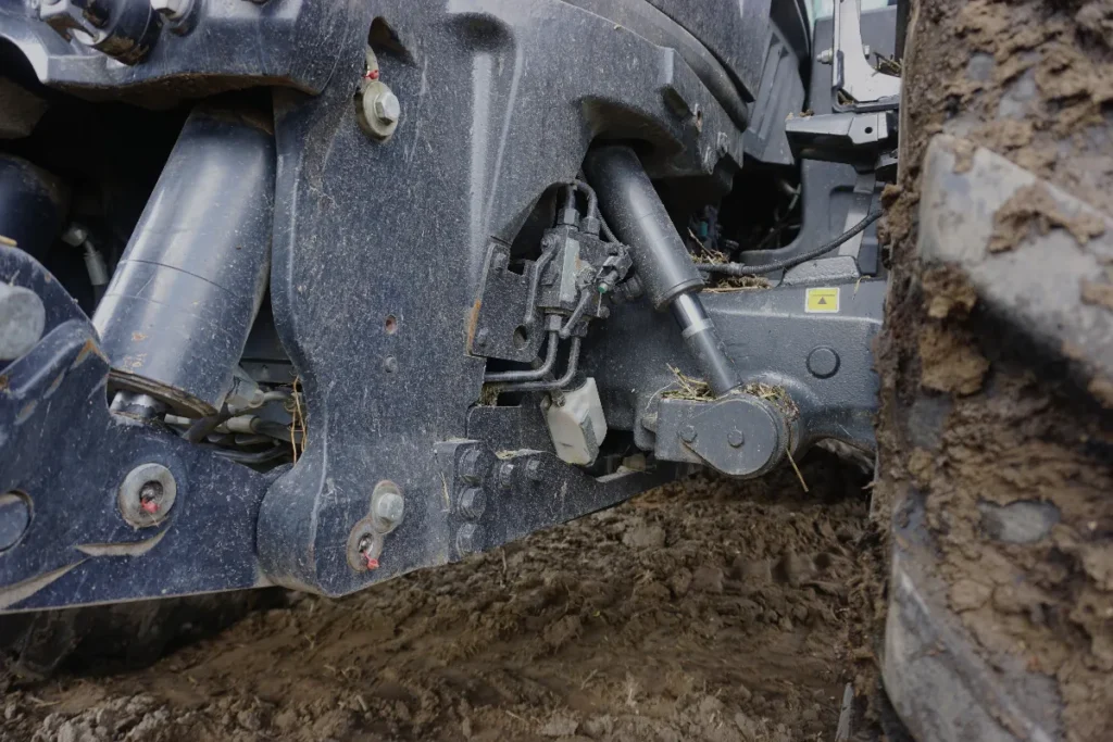 Jazdę traktorem po nierównościach ułatwia oś przednia z amortyzacją. Można pracować w trybie automatycznym, manualnym lub ją wyłączyć © TRAKTOR24.pl